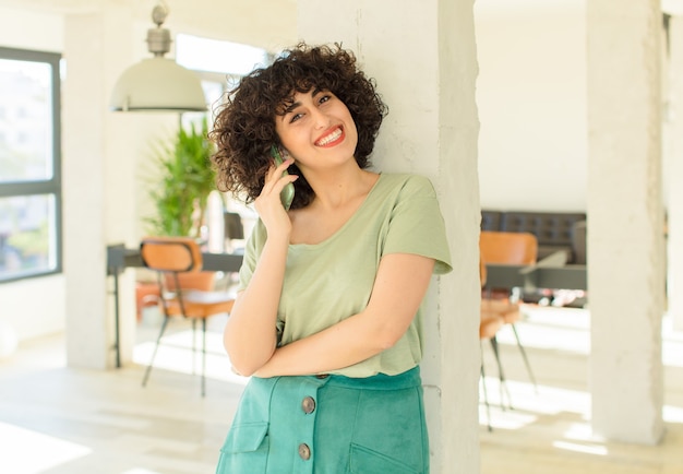 Mulher jovem e bonita usando seu smartphone em casa