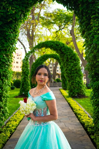 Mulher jovem e bonita vestida com fantasia de princesa no meio do arco de plantas