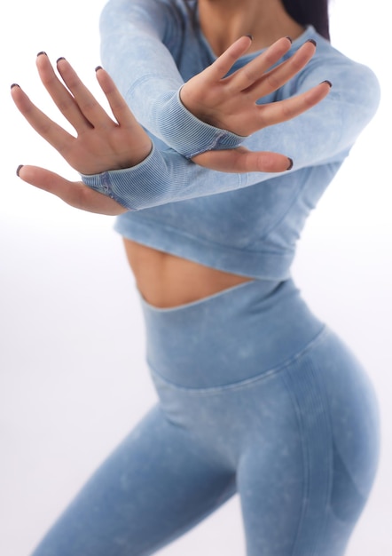 Mulher jovem e bonita vestida com um uniforme esportivo posando no estúdio em um fundo cinza