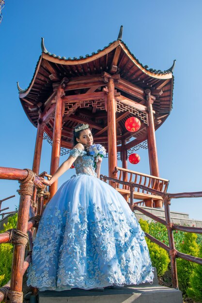 Mulher jovem e bonita vestida com uma fantasia de princesa posando em uma paisagem de tipo oriental.