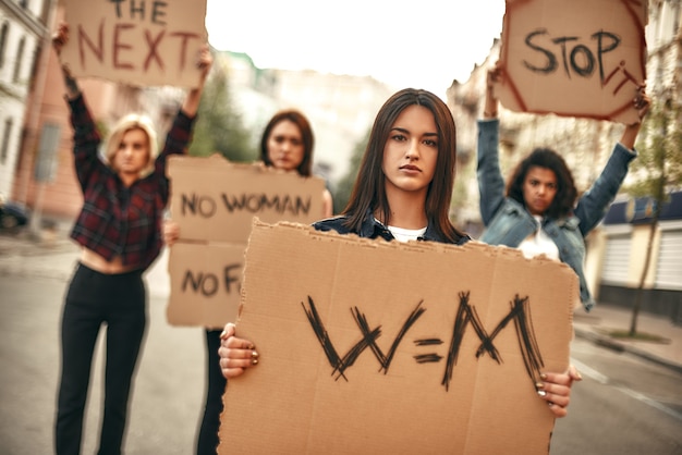 Mulher jovem e confiante protestando pela igualdade e segurando uma tabuleta