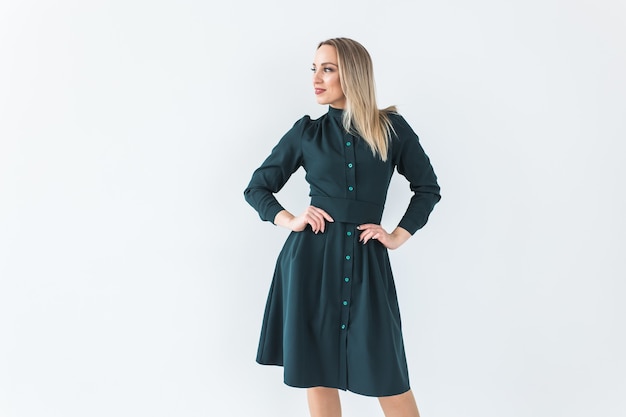 Mulher jovem e elegante loira em um lindo vestido elegante, posando no estúdio branco com espaço de cópia.