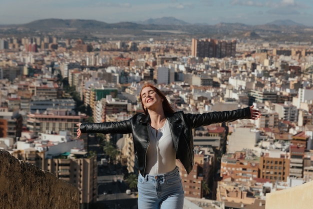 Mulher jovem e feliz bonita aprecia a vista da cidade