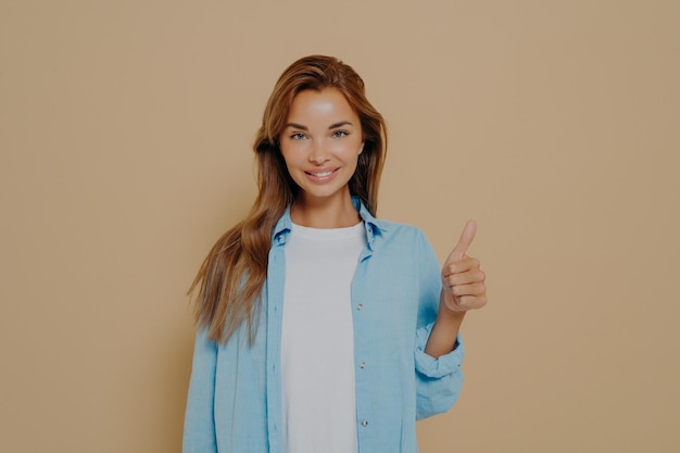 Mulher jovem e feliz, branca, de camisa azul com mangas compridas