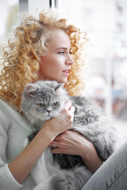 Mulher jovem e gato no quarto