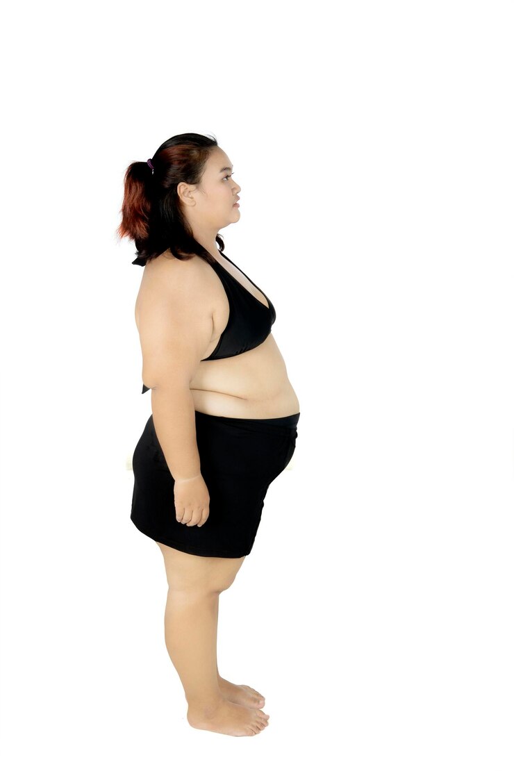 Foto mulher jovem e gorda de pé no estúdio.