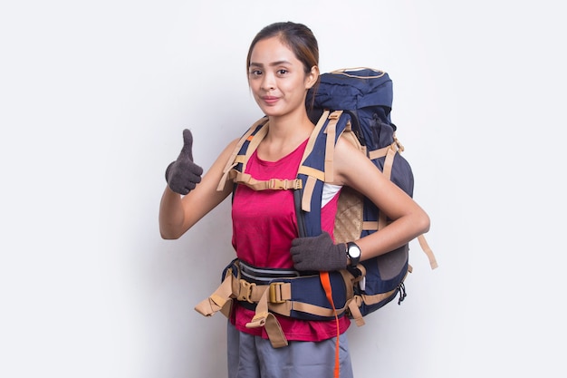Mulher jovem e linda alpinista asiática com mochila mostrando um gesto de ok com o polegar para cima no fundo branco