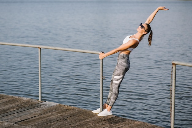 Mulher jovem e magra fazendo exercícios no fundo do lago