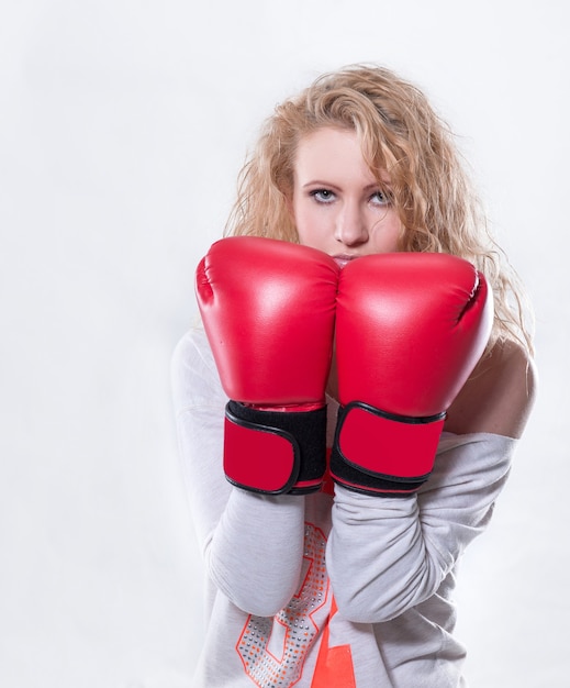 Mulher jovem e moderna com luvas de boxe vermelhas .isolada em fundo branco