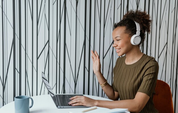 Mulher jovem e moderna trabalhando em casa em seu laptop