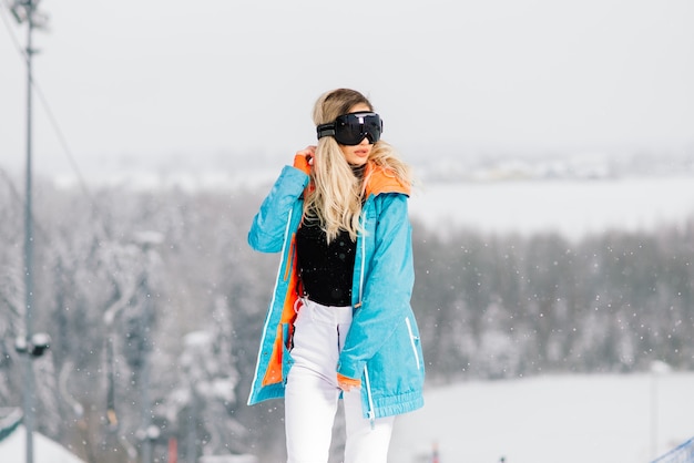 Mulher jovem e sorridente desportiva no inverno com snowboard