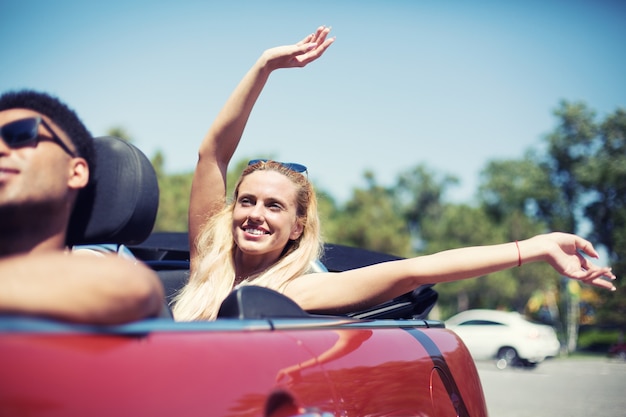 Mulher jovem em carro cabriolet partindo para as férias de verão