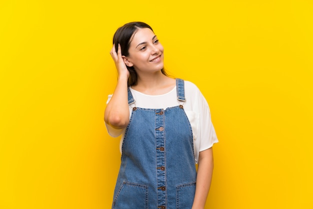 Mulher jovem, em, dungarees, pensando, um, idéia