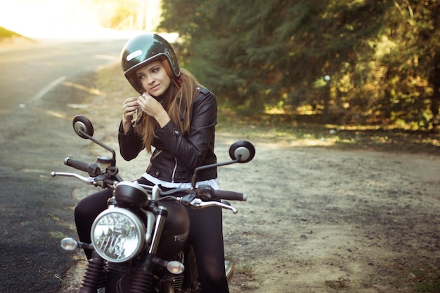 Mulher jovem em motocicleta na estrada