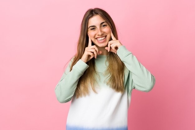 Mulher jovem em rosa isolada sorrindo com uma expressão feliz e agradável