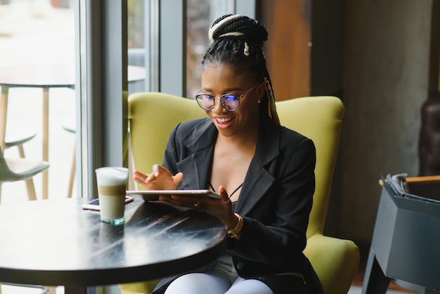 Mulher jovem em um café usando um tablet