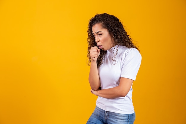 Mulher jovem em um fundo isolado está sofrendo de tosse e se sentindo mal