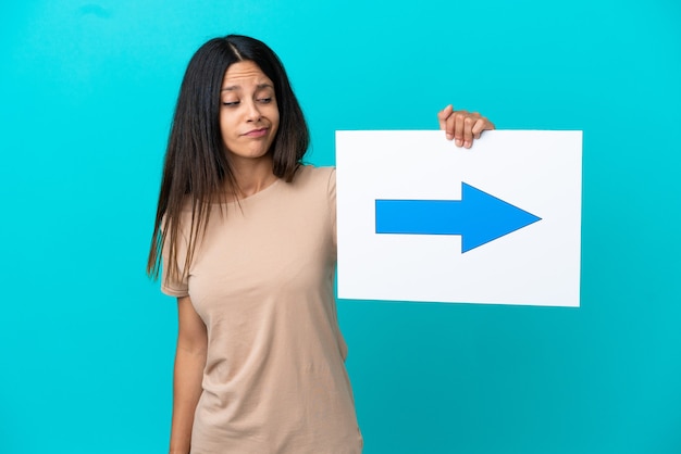 Foto mulher jovem em um fundo isolado segurando um cartaz com o símbolo de seta