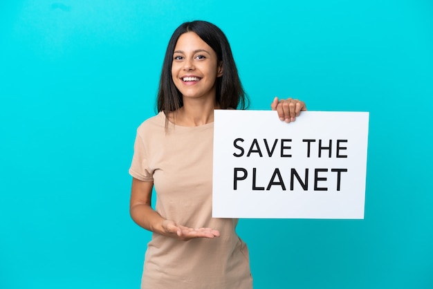 Mulher jovem em um fundo isolado segurando um cartaz com o texto salve o planeta e apontando-o
