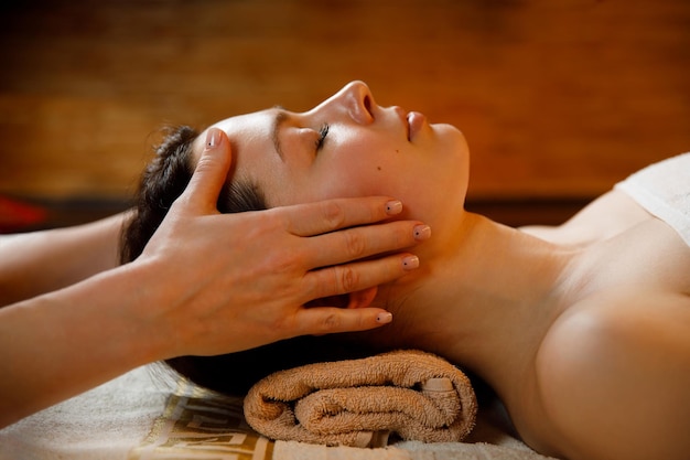 Mulher jovem em um procedimento de massagem facial de salão de spa