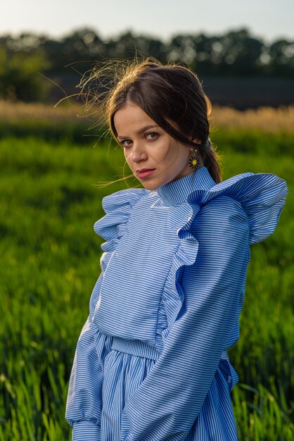 Mulher jovem em um vestido listrado azul e branco