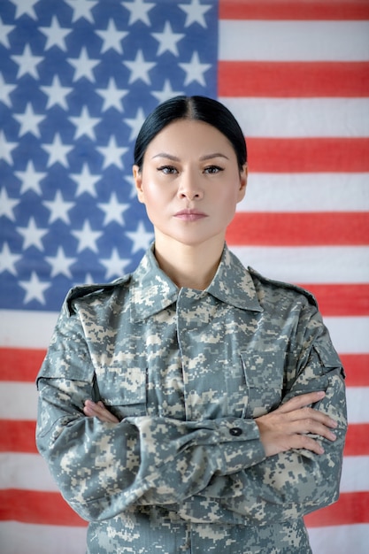 Mulher jovem em uniforme militar com a bandeira americana