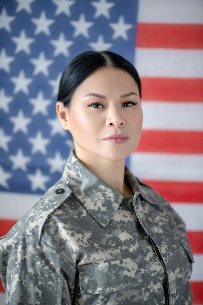 Mulher jovem em uniforme militar com a bandeira americana