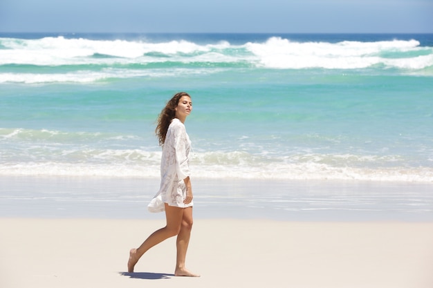 Mulher jovem, em, vestido verão, andar, praia