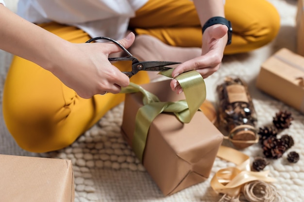 Mulher jovem embrulhando presentes de natal para o feriado