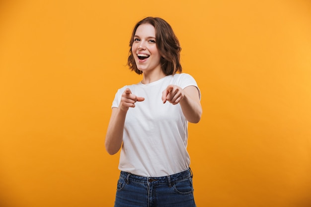 Mulher jovem emocional feliz apontando para você.