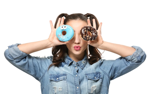 Mulher jovem engraçada com rosquinhas saborosas no fundo branco