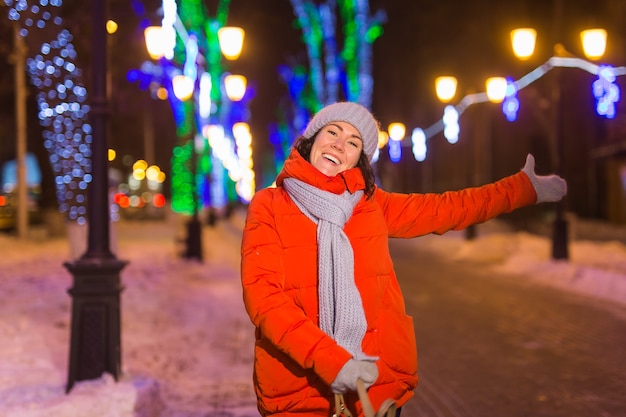 Mulher jovem engraçada feliz com roupas de inverno, noite, cidade, luzes, iluminação, natal