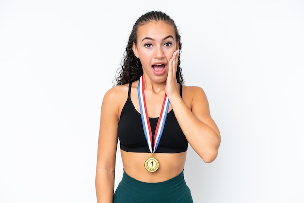 Mulher jovem esporte com medalhas isoladas no fundo branco com surpresa e expressão facial chocada