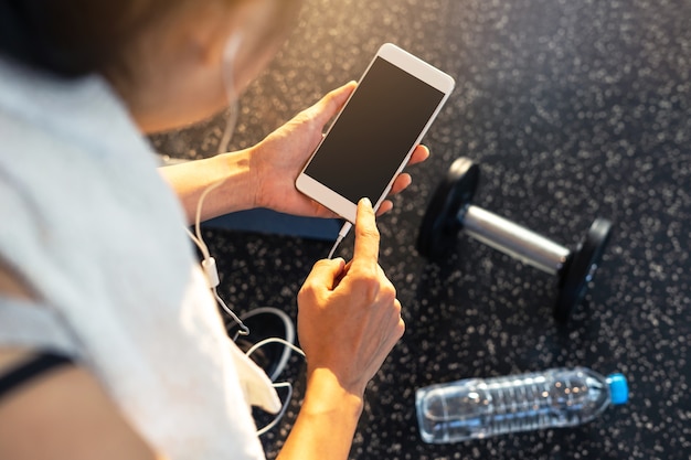 Mulher jovem esporte no ginásio usando smartphone, Fitness, conceito de estilo de vida de formação