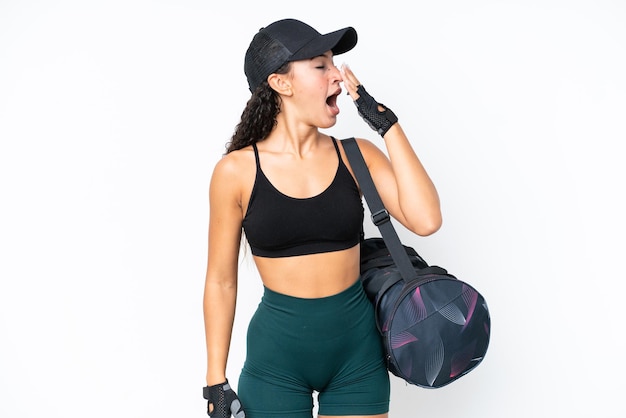 Mulher jovem esportiva com bolsa esportiva isolada em fundo branco, bocejando e cobrindo a boca aberta com a mão