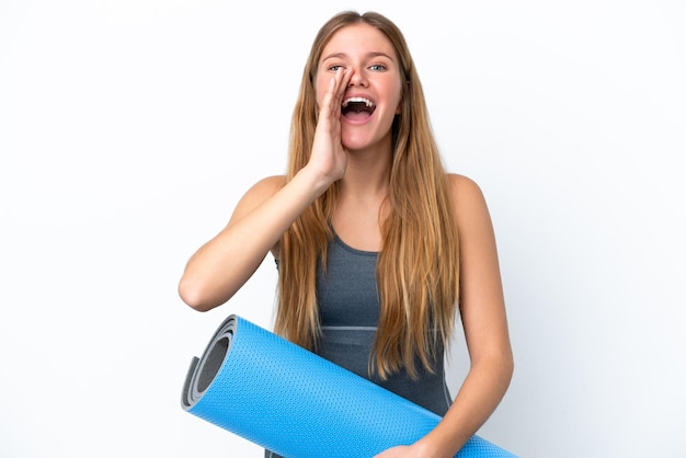 Mulher jovem esportiva indo para aulas de ioga enquanto segura um tapete gritando com a boca aberta