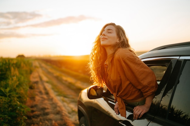 Mulher jovem está descansando e desfrutando do pôr-do-sol no carro Estilo de vida viagens turismo natureza vida ativa