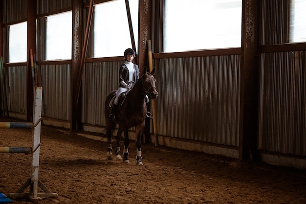 Mulher jovem está envolvida em esportes equestres, treinando a cavalo