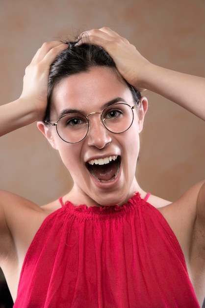 Mulher jovem estressada com óculos gritando retrato