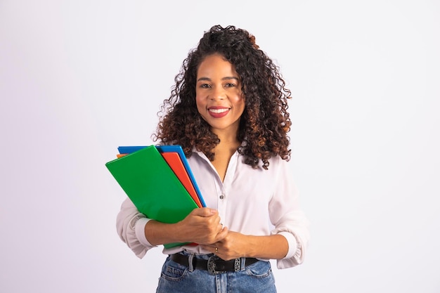 Mulher jovem estudante afro segurando cadernos em fundo branco faculdade de ensino médio e conceito de estudante universitário