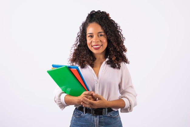 Mulher jovem estudante afro segurando cadernos em fundo branco faculdade de ensino médio e conceito de estudante universitário