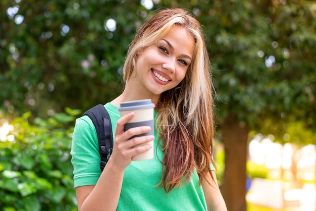 Mulher jovem estudante ao ar livre com uma expressão feliz