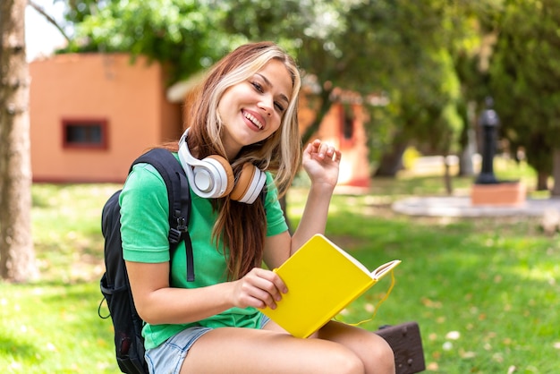 Mulher jovem estudante ao ar livre segurando um caderno