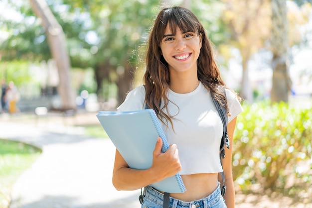 Mulher jovem estudante ao ar livre sorrindo muito