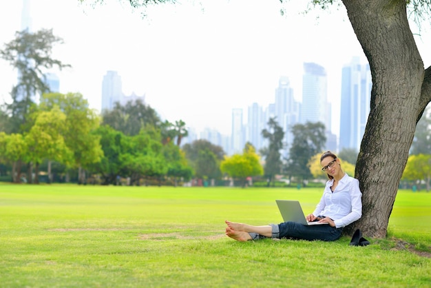 mulher jovem estudante feliz com laptop no estudo do parque da cidade