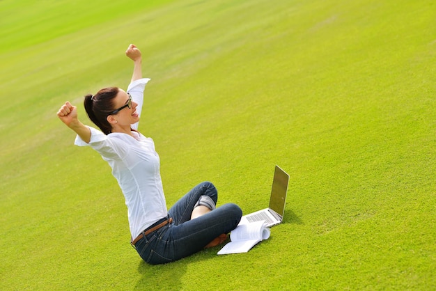 mulher jovem estudante feliz com laptop no estudo do parque da cidade