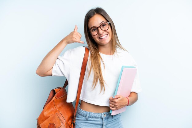 Mulher jovem estudante isolada em fundo azul fazendo gesto de telefone Ligue-me de volta sinal