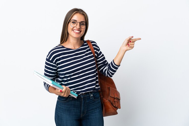 Foto mulher jovem estudante isolada em um fundo branco apontando o dedo para o lado