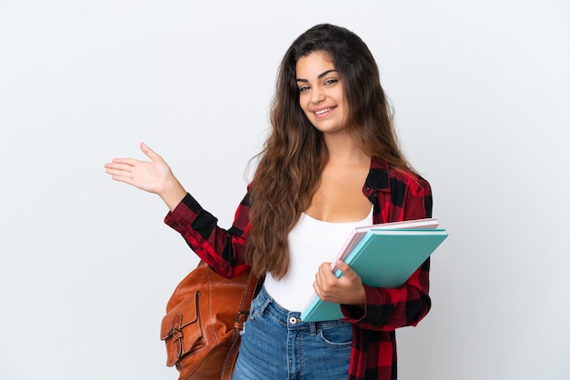 Mulher jovem estudante isolada em um fundo branco, estendendo as mãos para o lado para convidar para vir