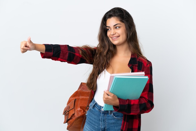 Mulher jovem estudante isolada no fundo branco fazendo um gesto de polegar para cima